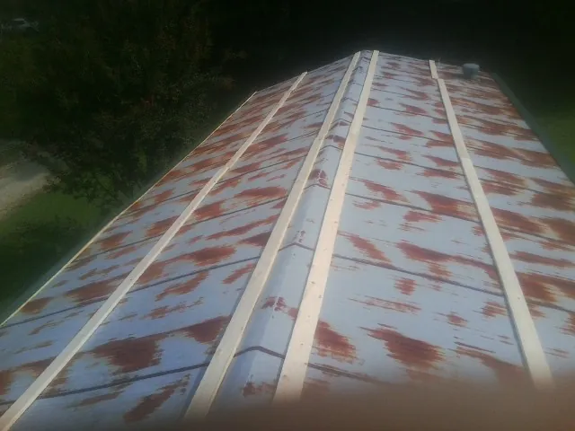 Rusted metal roof panels with new wood purlins before replacement — Storm Damage Roof Repair in Rising City by Roofing Brothers